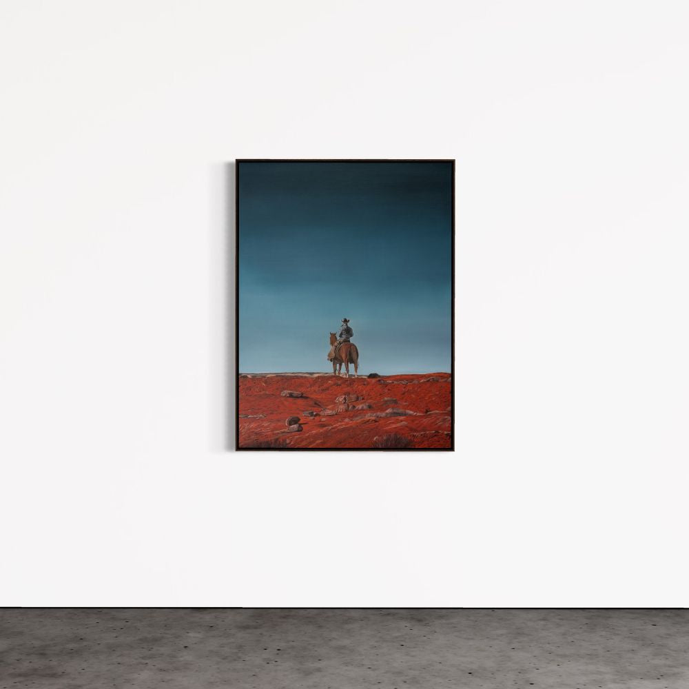 Framed artwork of a person on horseback in a desert landscape with a blue sky.