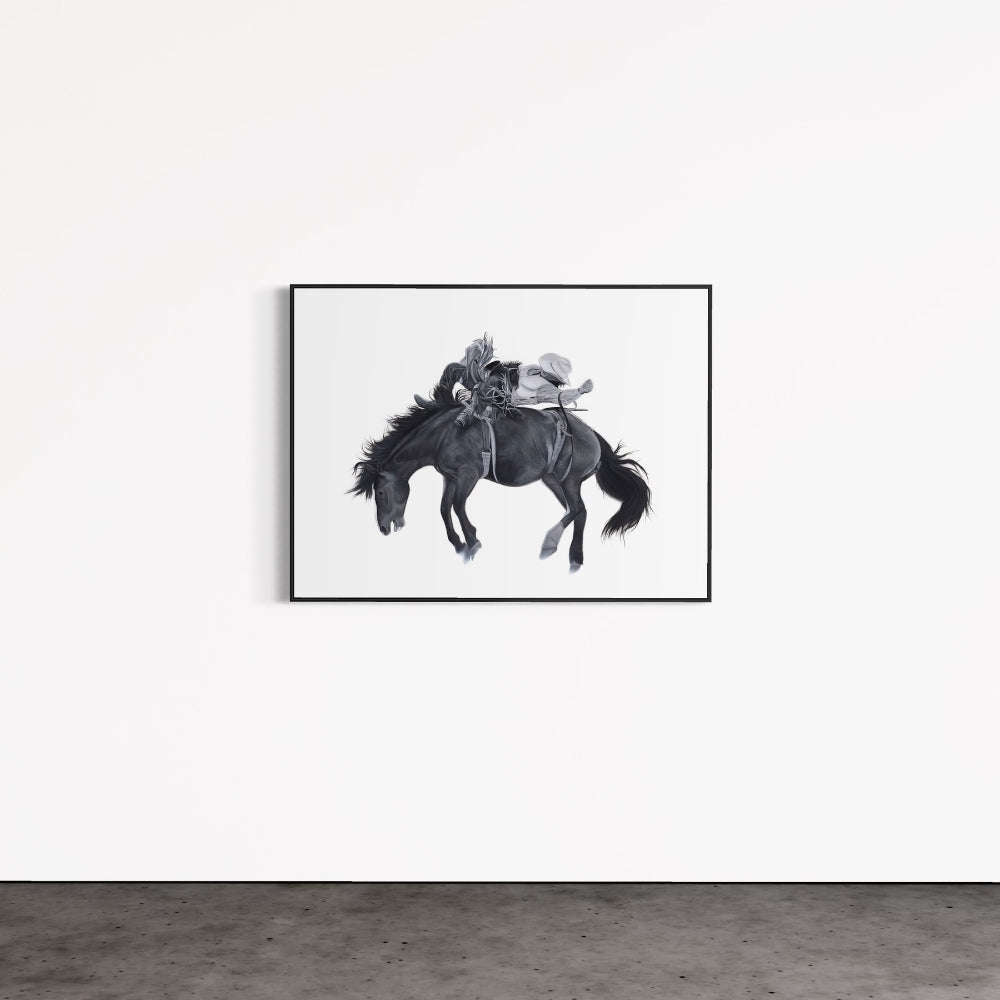 Framed artwork of a horse and rider on a white wall