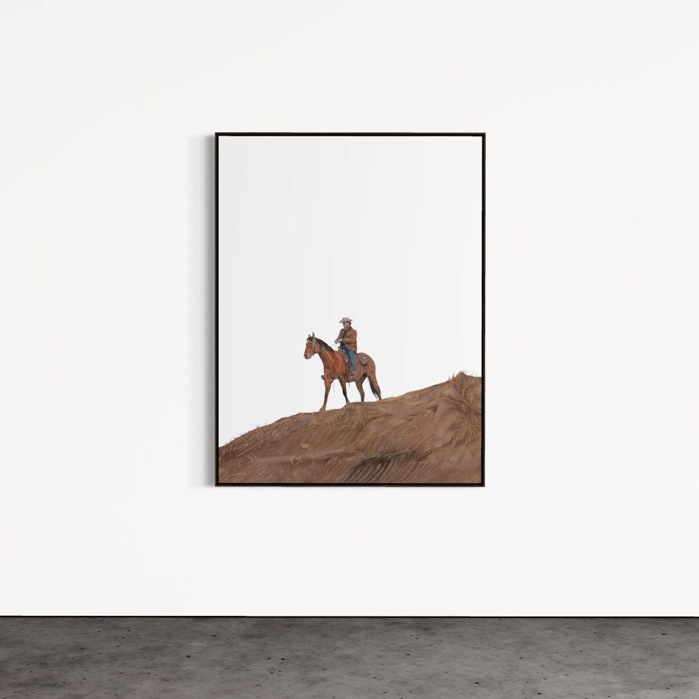 Framed artwork of a person riding a horse on a hillside against a white wall.