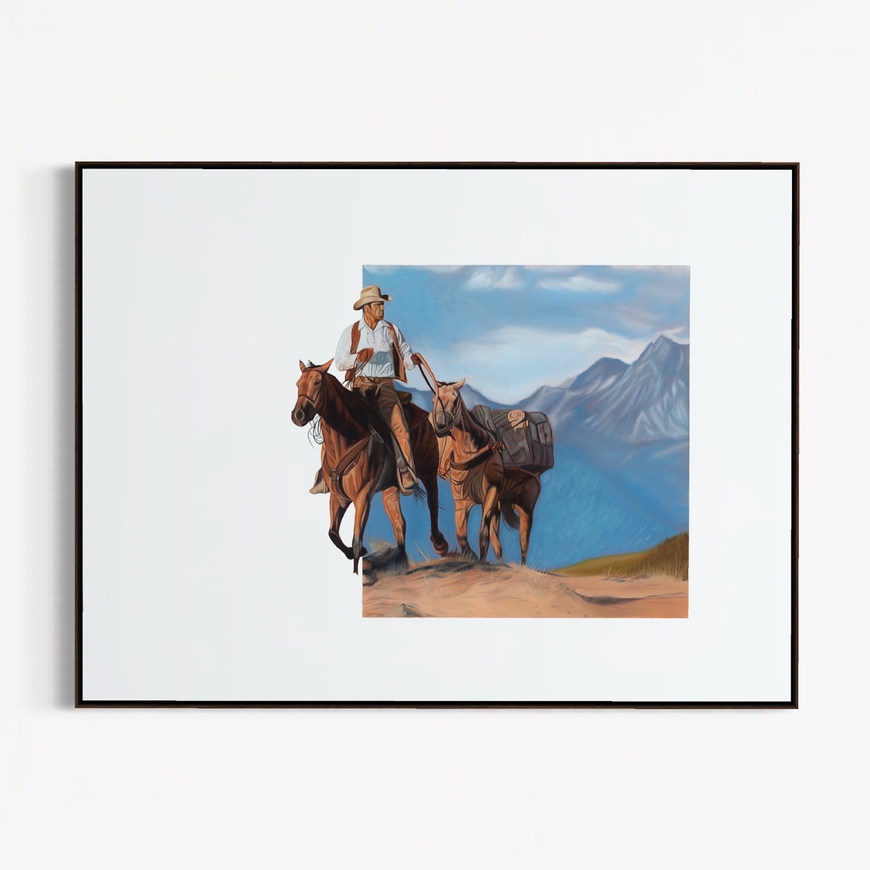 Framed artwork of a cowboy on horseback with mountains in the background