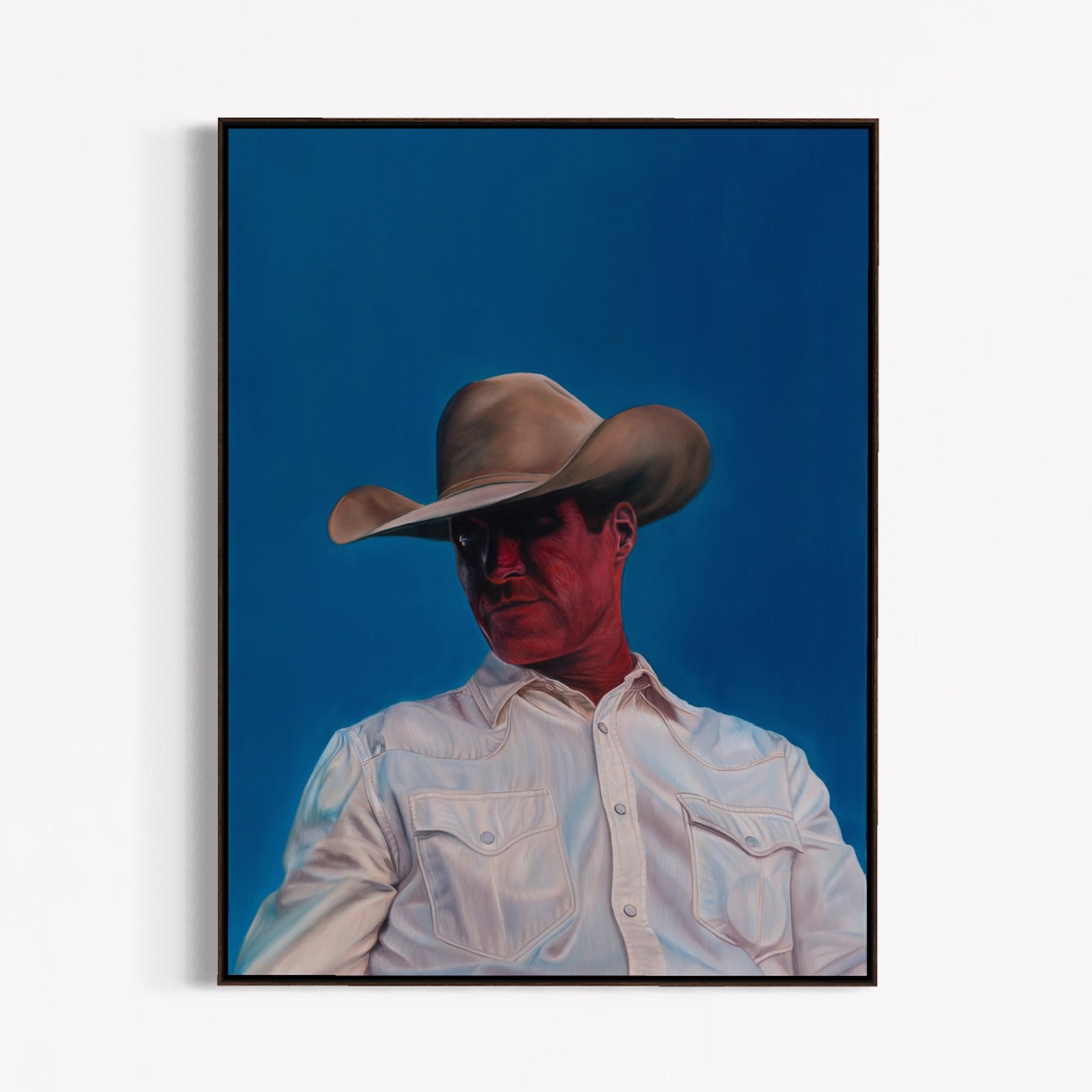 Framed artwork of a person wearing a cowboy hat and light-colored shirt against a blue background