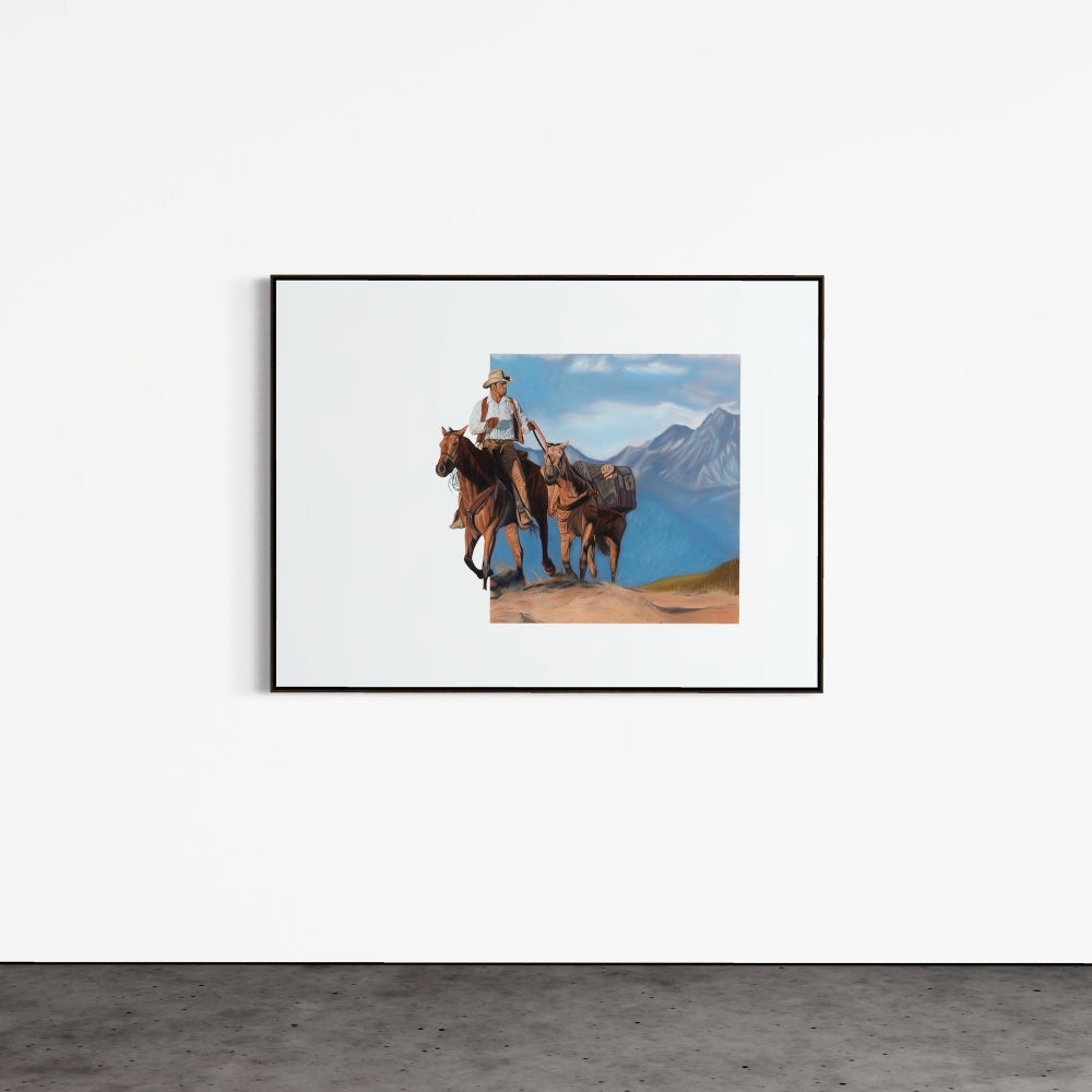 Framed picture of a person riding a horse with mountains in the background on a white wall.