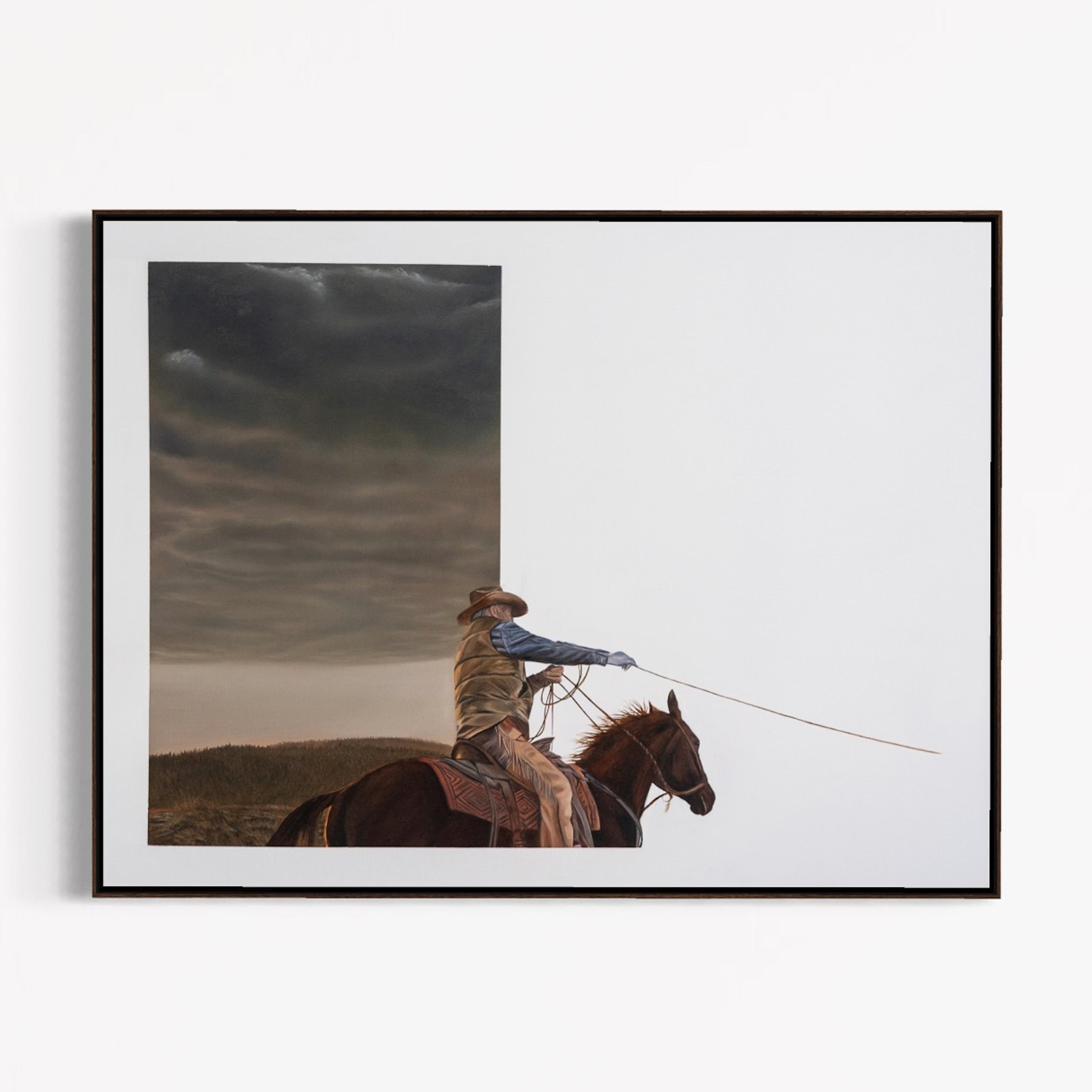 Framed artwork of a cowboy on horseback against a stormy sky.