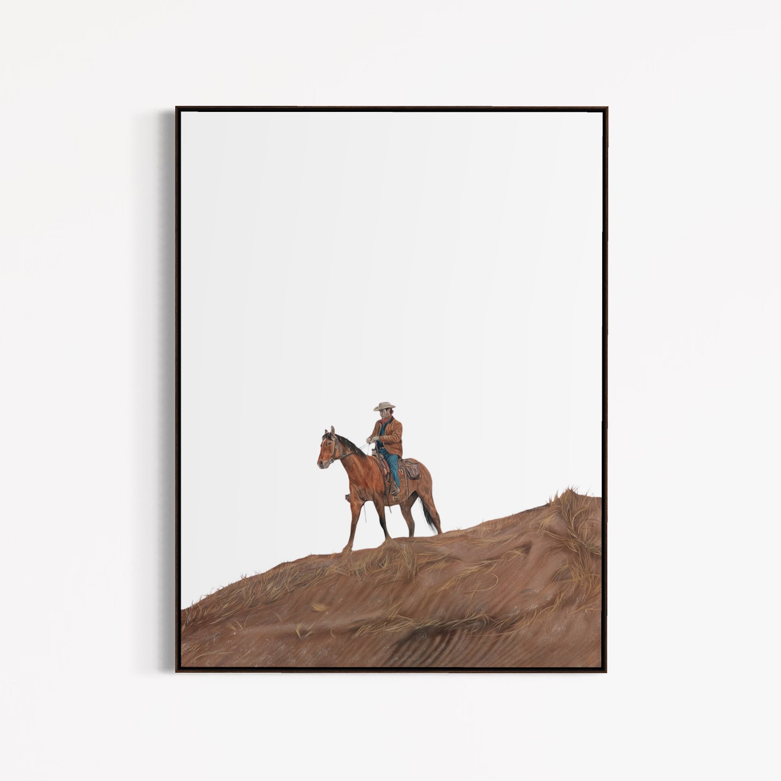 Framed artwork of a cowboy on horseback in a desert landscape.