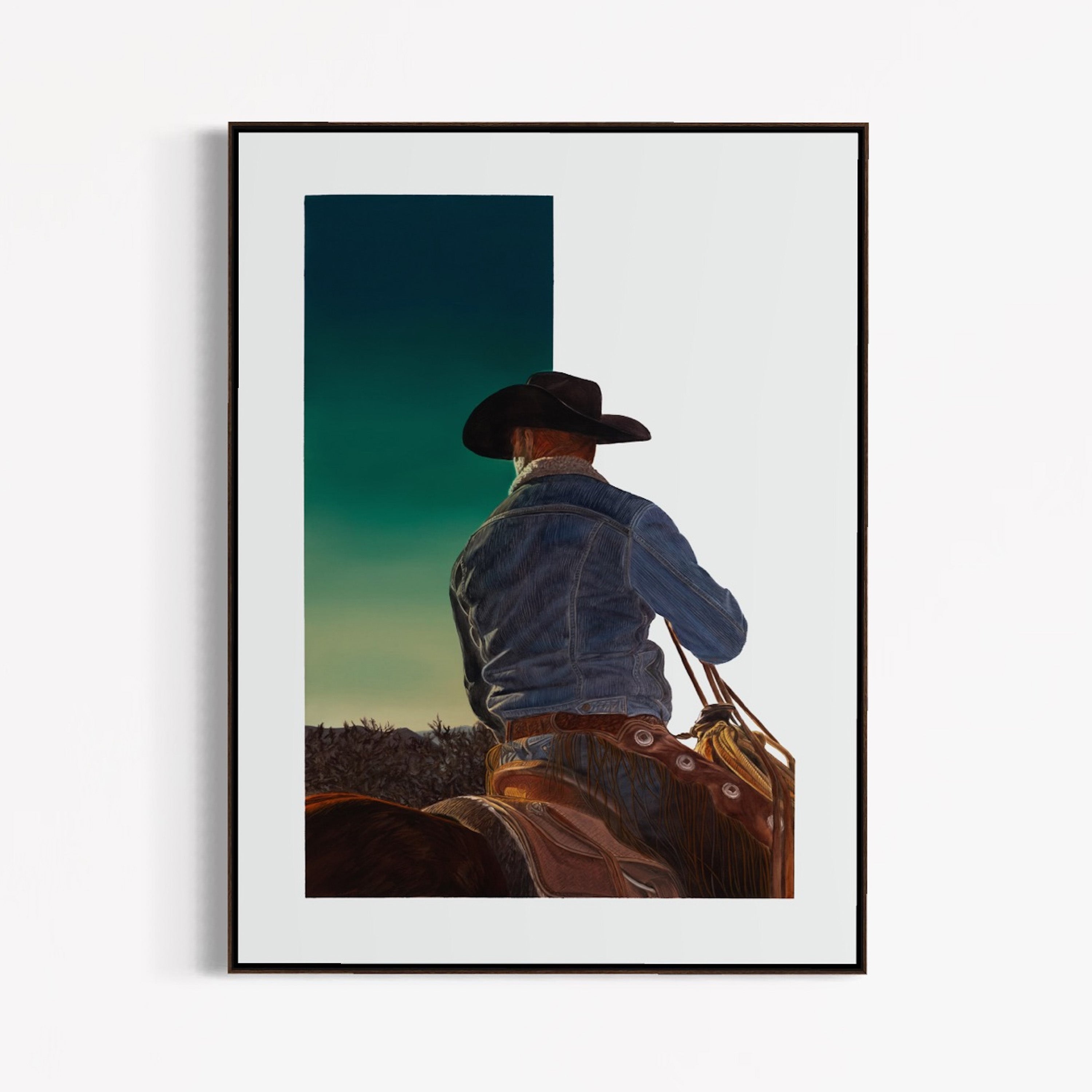 Framed artwork of a cowboy on horseback with a scenic background