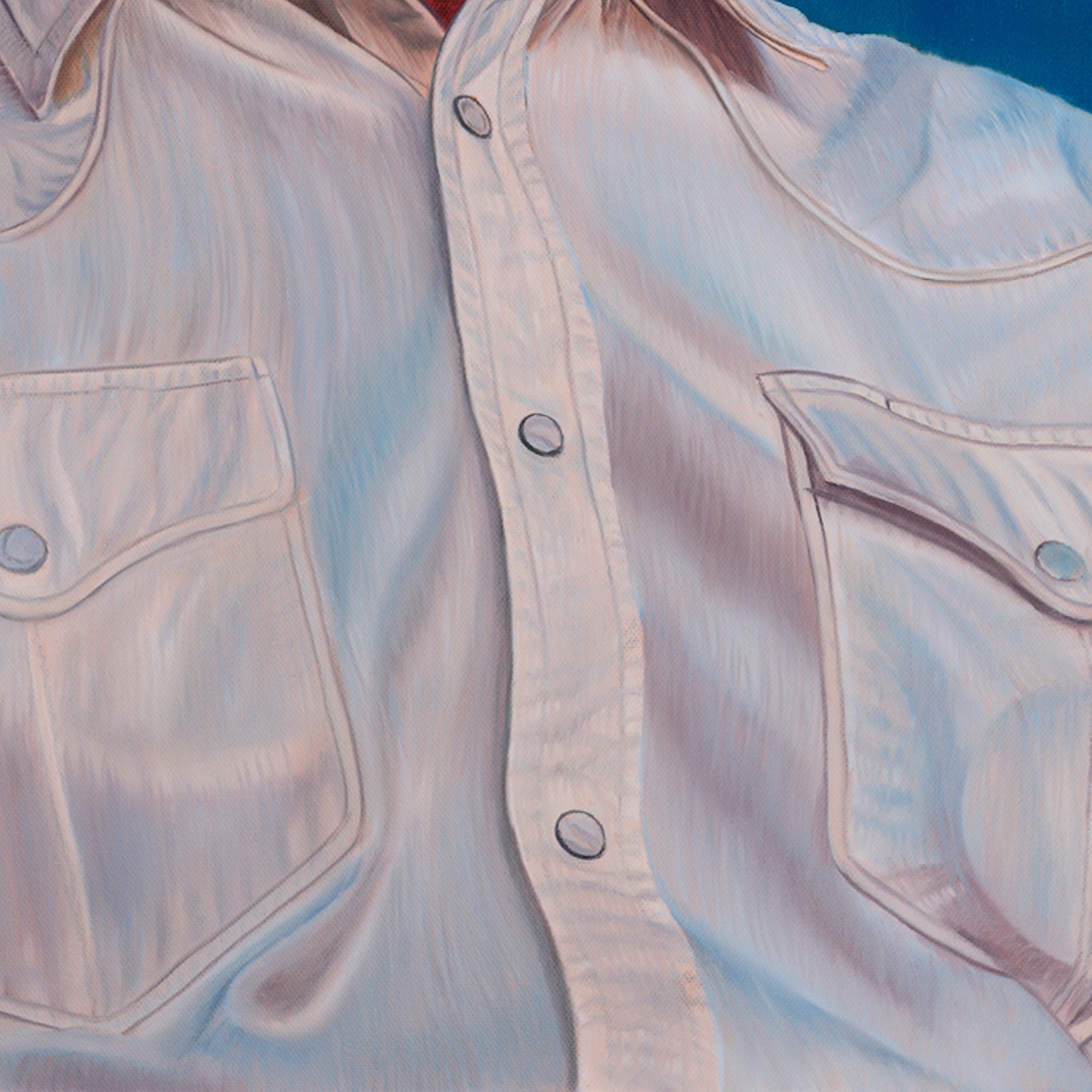Close-up of a light-colored denim shirt with button details on a blue background