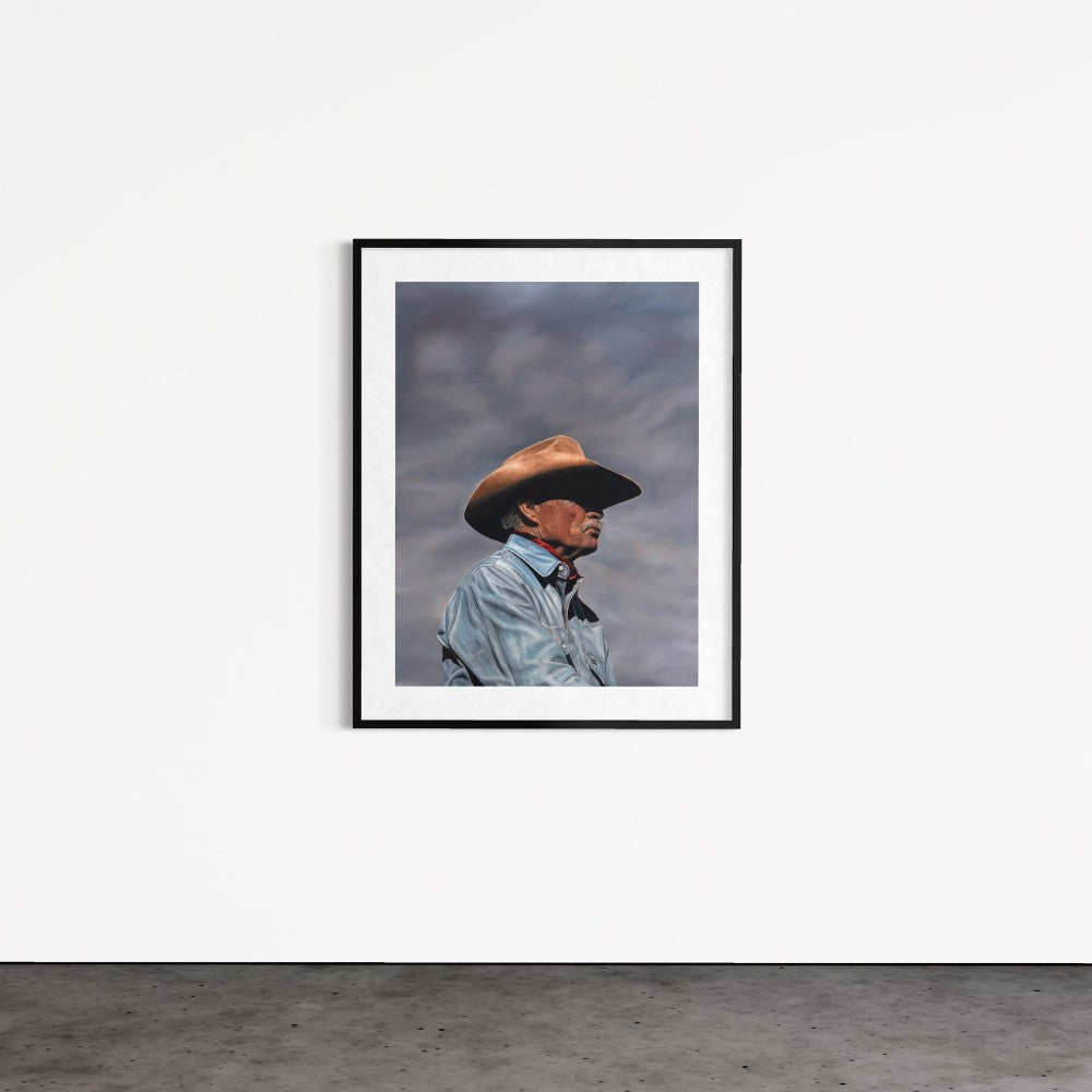 Framed picture of a person wearing a cowboy hat against a cloudy sky.