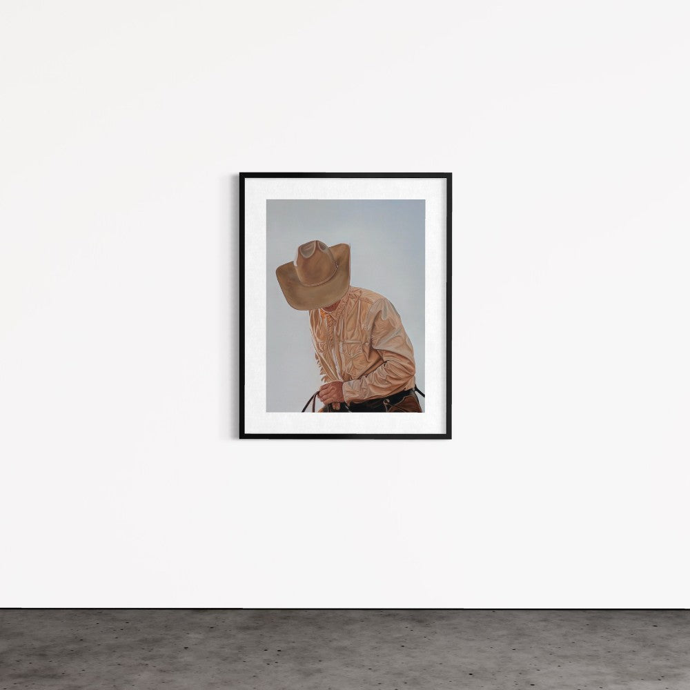 Framed artwork of a person wearing a cowboy hat and light brown shirt on a white wall.