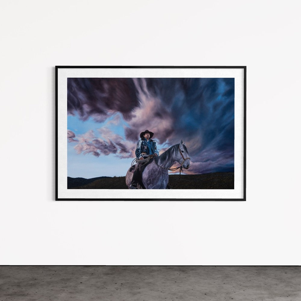 Framed artwork of a person on horseback against a dramatic sky with swirling clouds.