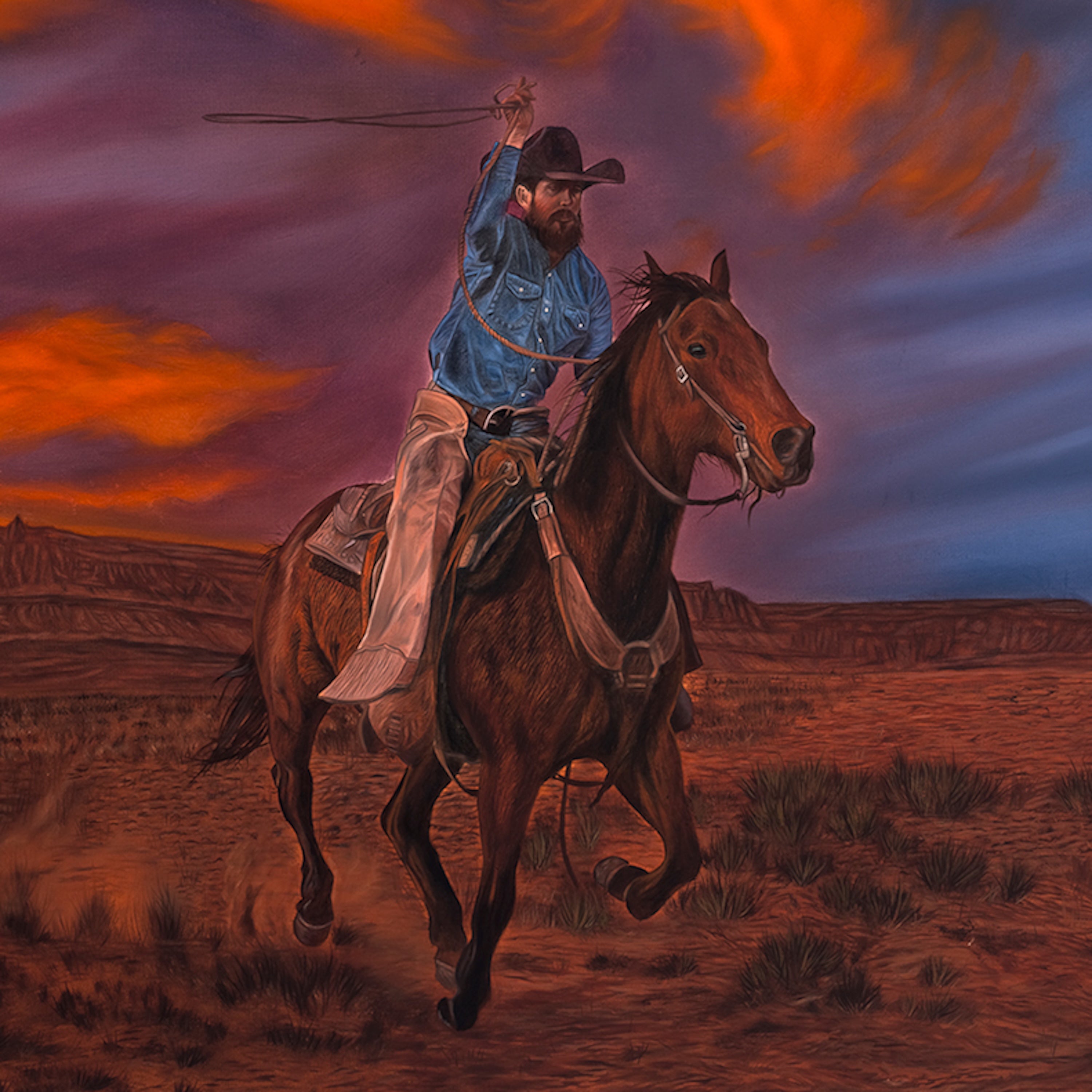 Cowboy on horseback against a dramatic sunset sky in a desert landscape