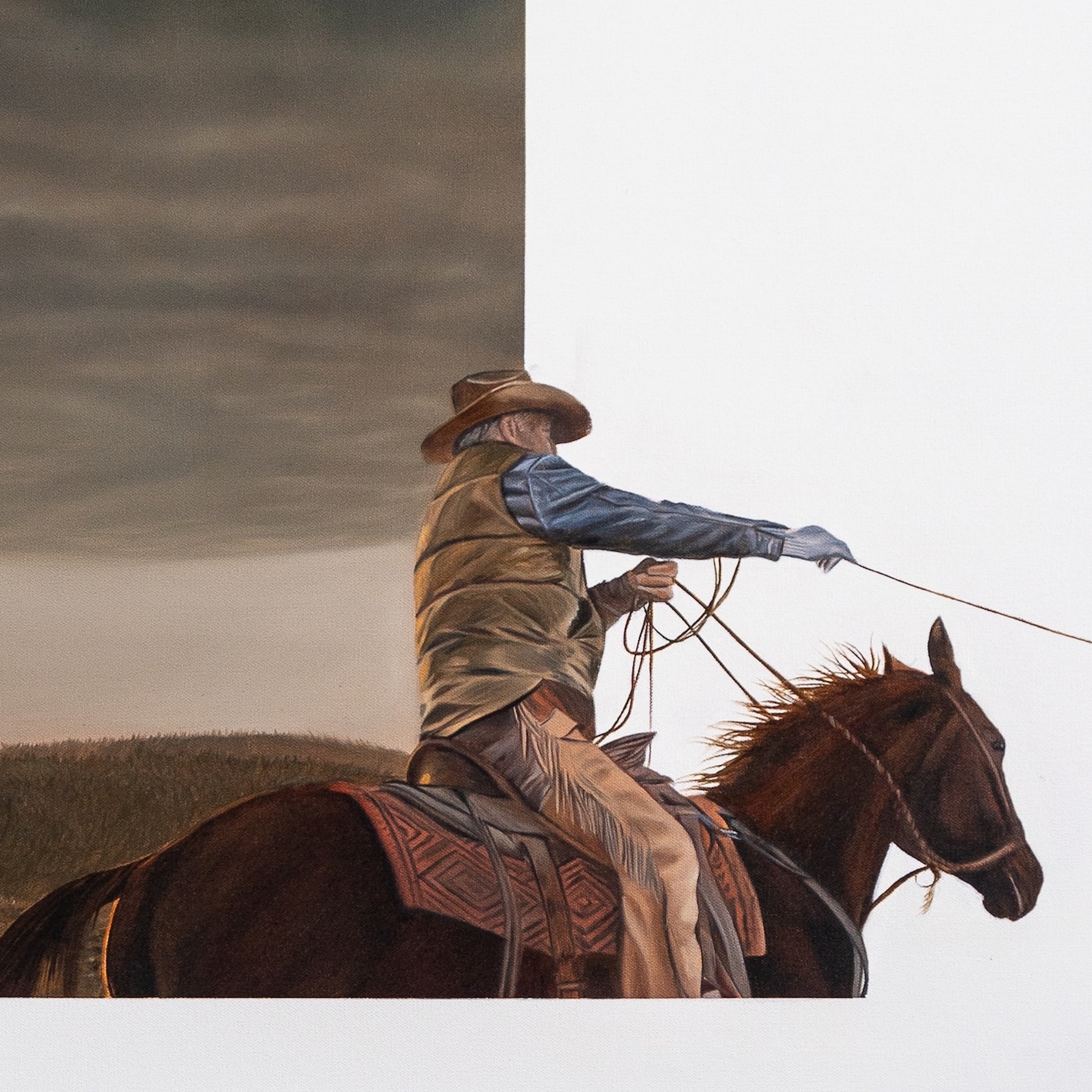 Cowboy on horseback with a lasso against a sky background