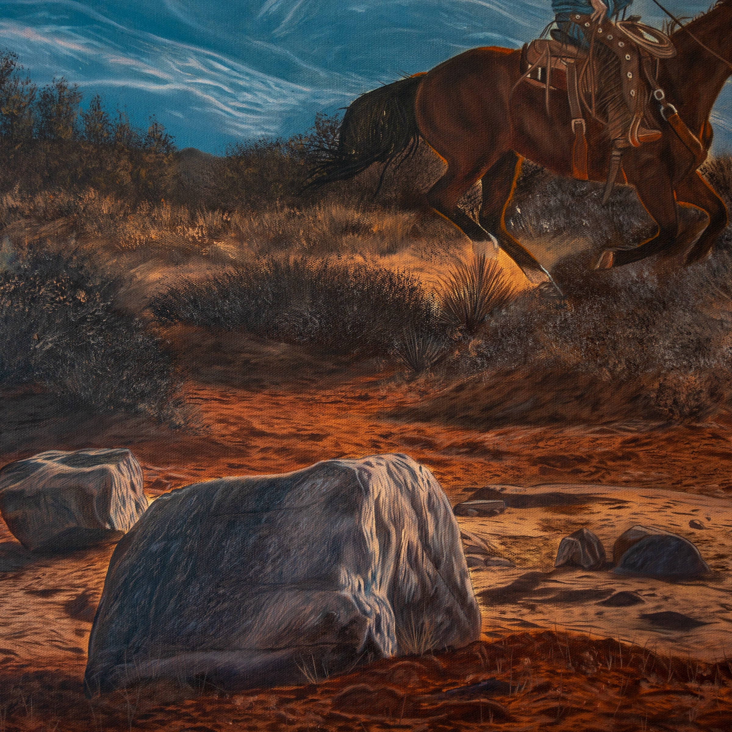 Horse and rider in a desert landscape with mountains in the background