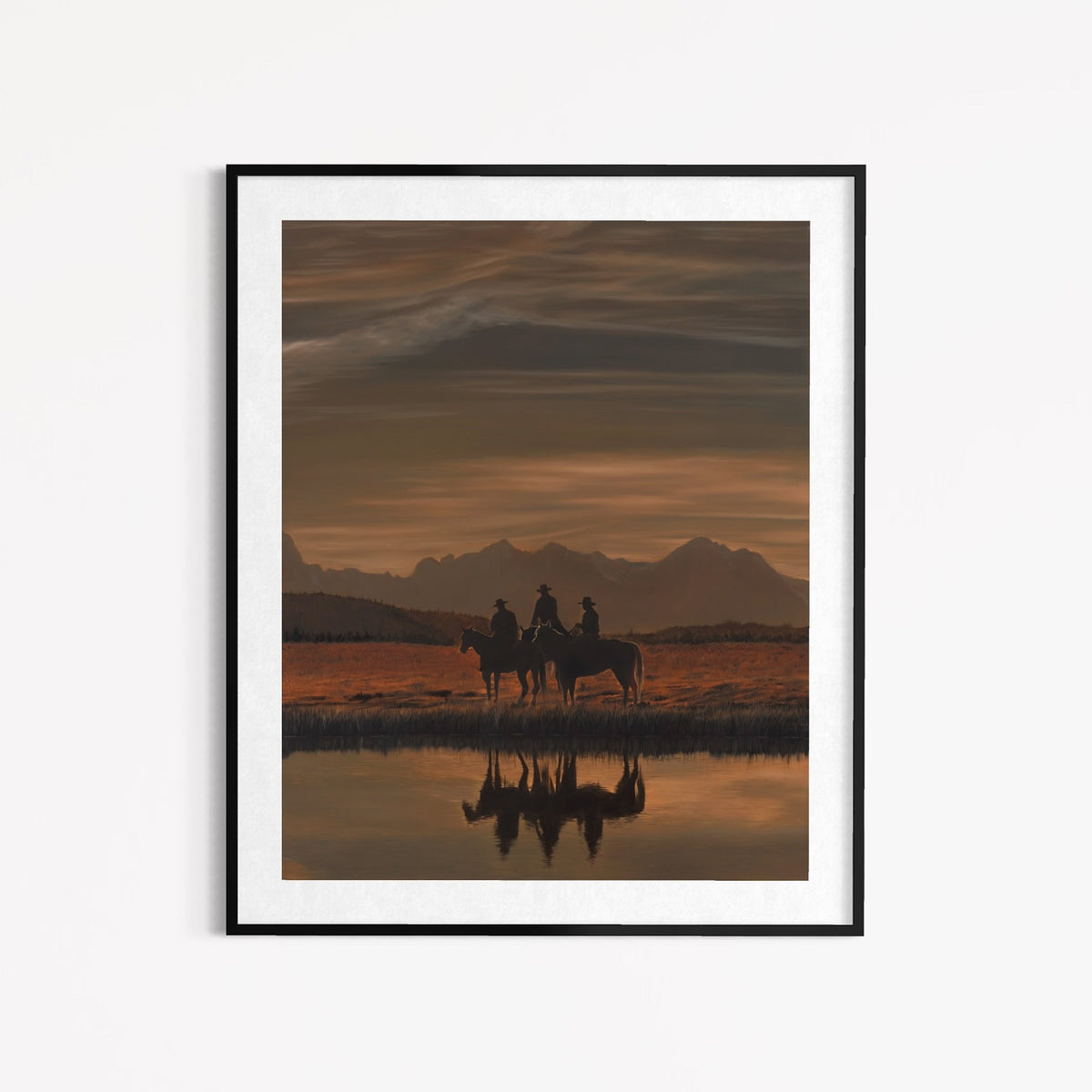 Framed artwork of two people on horseback at sunset with mountains in the background.