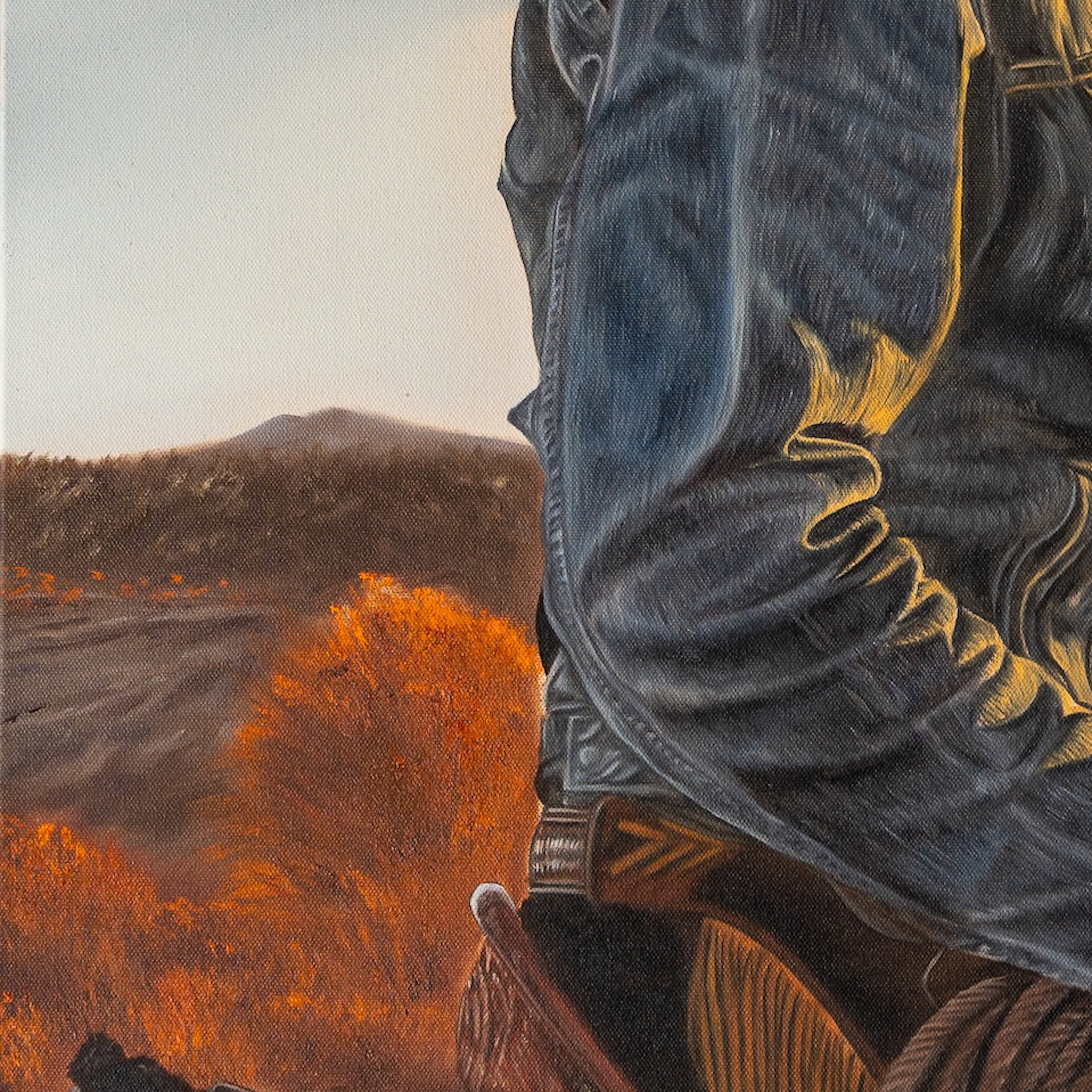 Close-up of a person wearing blue jeans with a scenic background of trees and mountains.